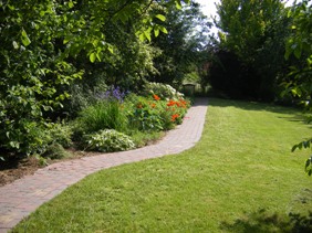 garden path leading to the gate betwin flowerbed and lawn